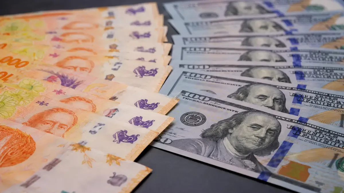 Billetes de pesos argentinos y dólares sobre una mesa